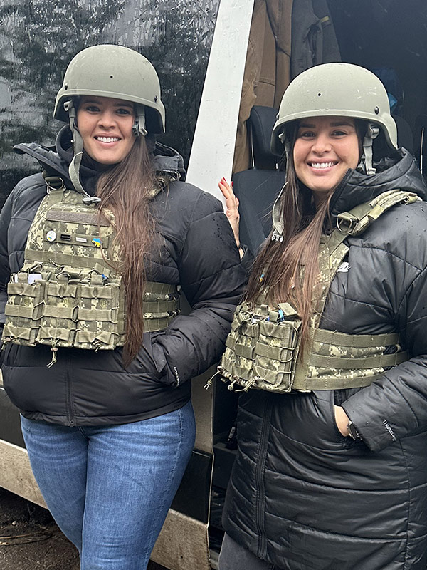 Founders Samantha and Hope with armored helmets and camouflage vests.